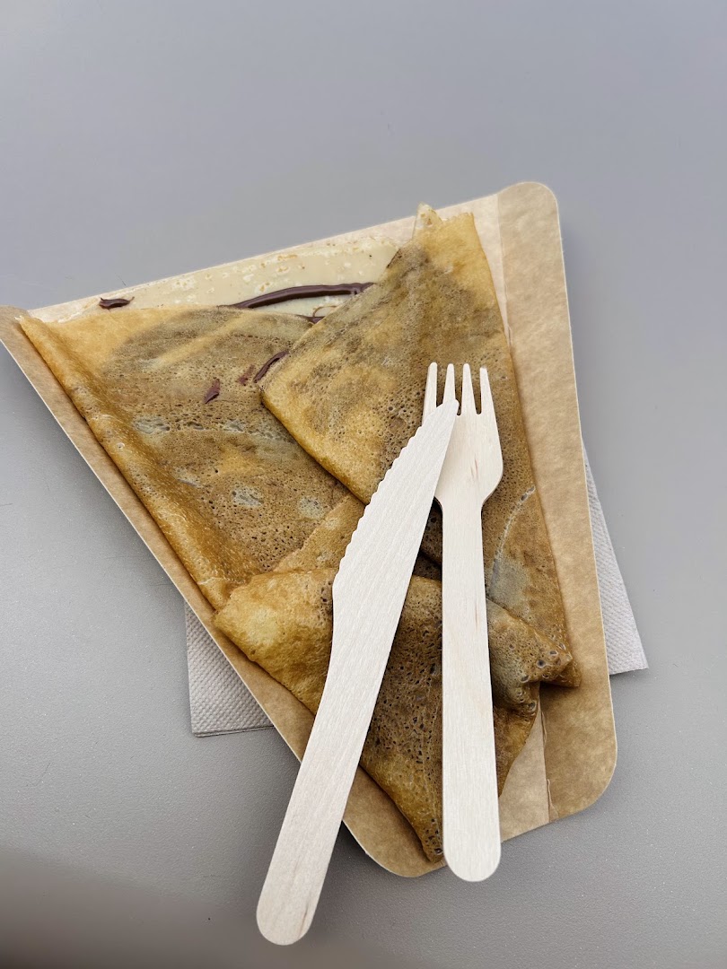 Une crêpe pliée servie avec une fourchette en bois