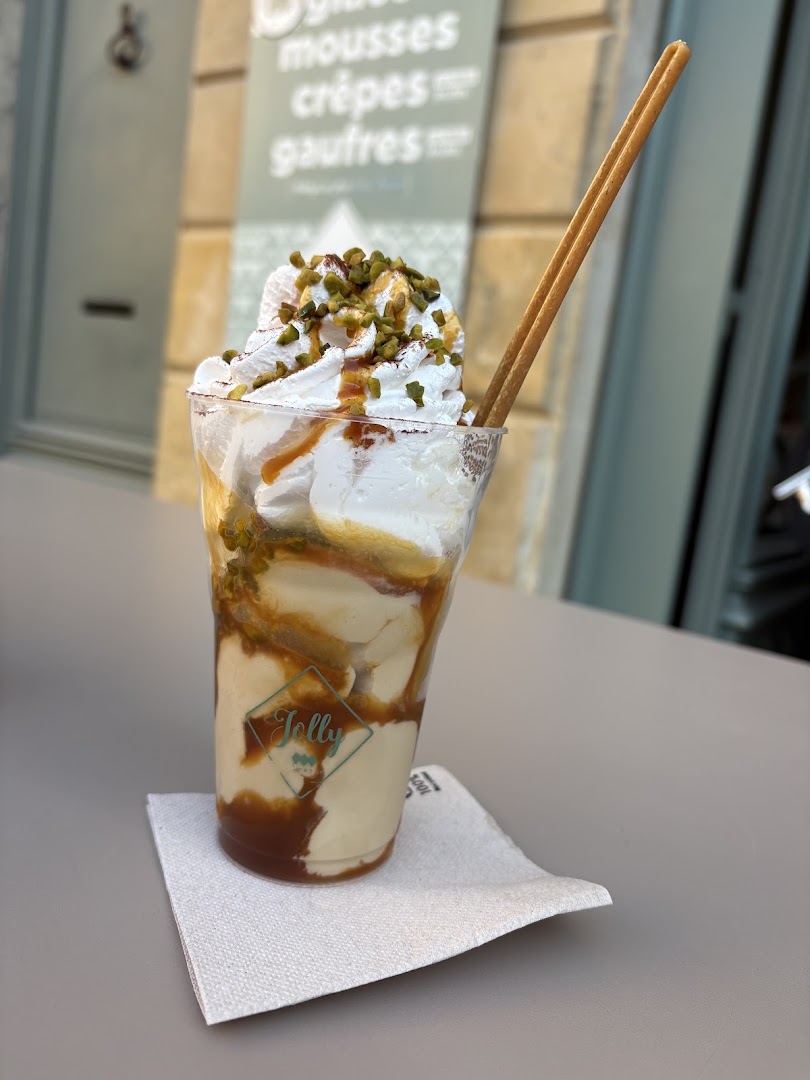 Une coupe glacée nappée de sauce et de crème fouettée